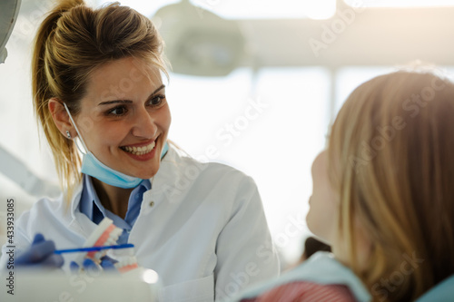 Close up photo of young beautiful female dentist working in dental office.