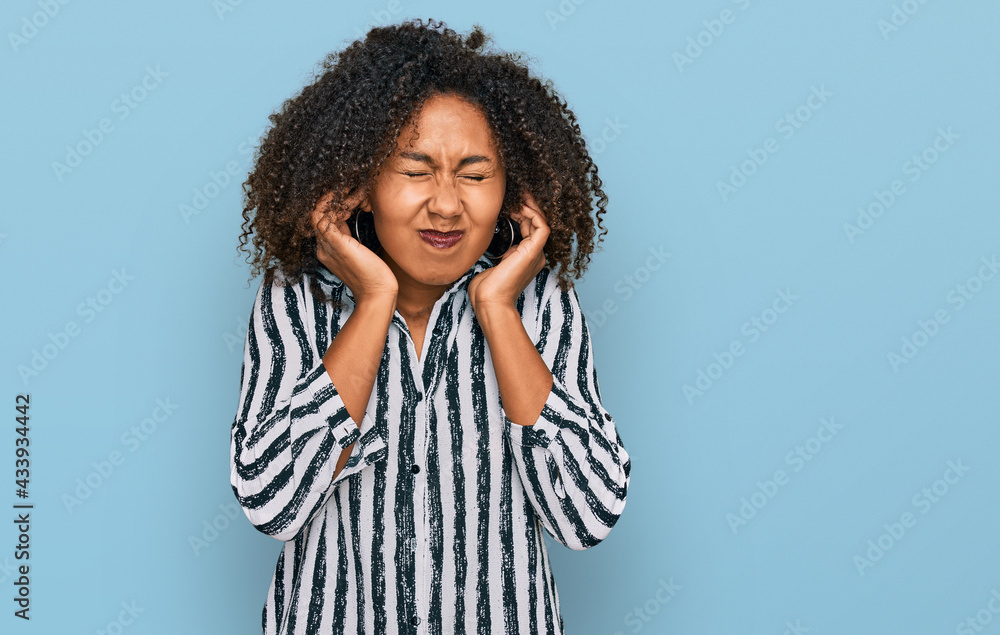 Young african american girl wearing casual clothes covering ears with fingers with annoyed expression for the noise of loud music. deaf concept.