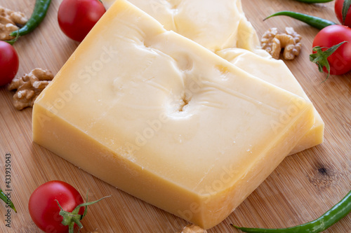 Gruyere cheddar cheese on wooden background. Local name gravyer peynir photo