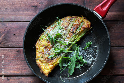 Padella con frittata di asparagi sulla tavola di legno. Cibo primaverile. Direttamente sopra.