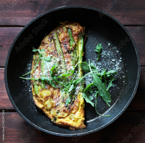 Padella con frittata di asparagi sulla tavola di legno. Cibo primaverile. Direttamente sopra.