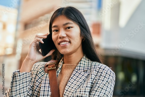 Young asian businesswoman smiling happy using smartphone at the city.