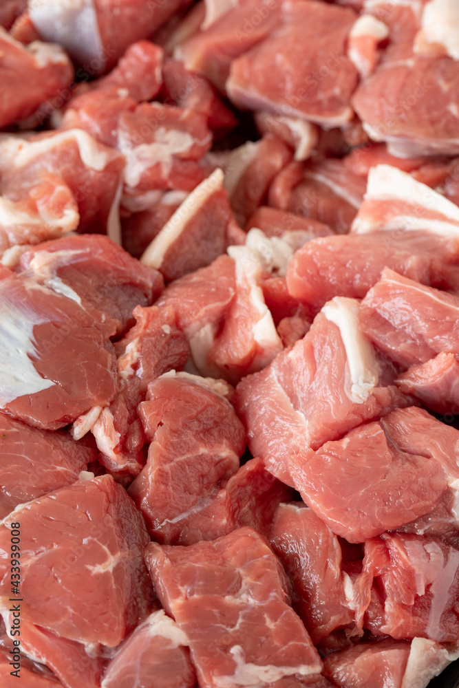 raw lamb cubed meat on white wooden background. Meat (food) backround. Close up lamb cube meat