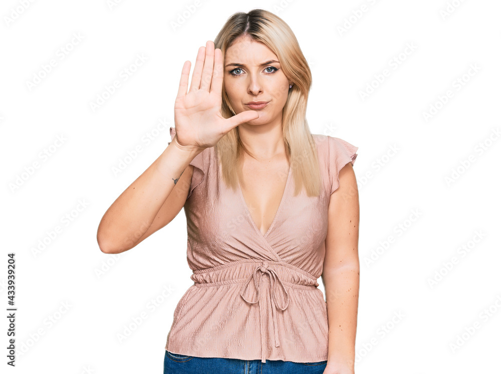 Young caucasian woman wearing casual clothes doing stop sing with palm of the hand. warning expression with negative and serious gesture on the face. Young caucasian woman wearing casual clothes doing stop sing with palm of the hand. warning expression with negative and serious gesture on the face.