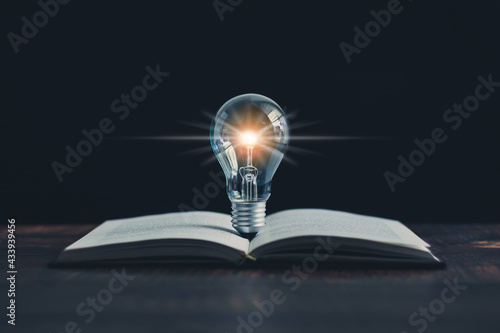 Glowing light bulb and book or text book with futuristic icon. Self learning or education knowledge and business studying concept. Idea of learning online class or e-learning at home.