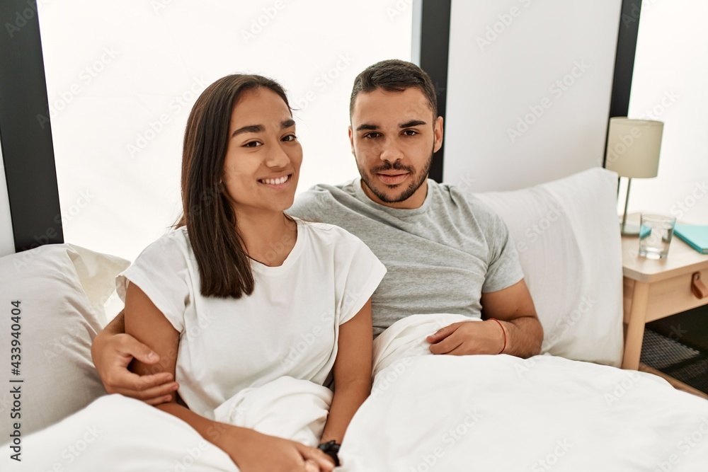 Young latin couple smiling happy hugging on the bed at home. Young latin couple smiling happy hugging on the bed at home.