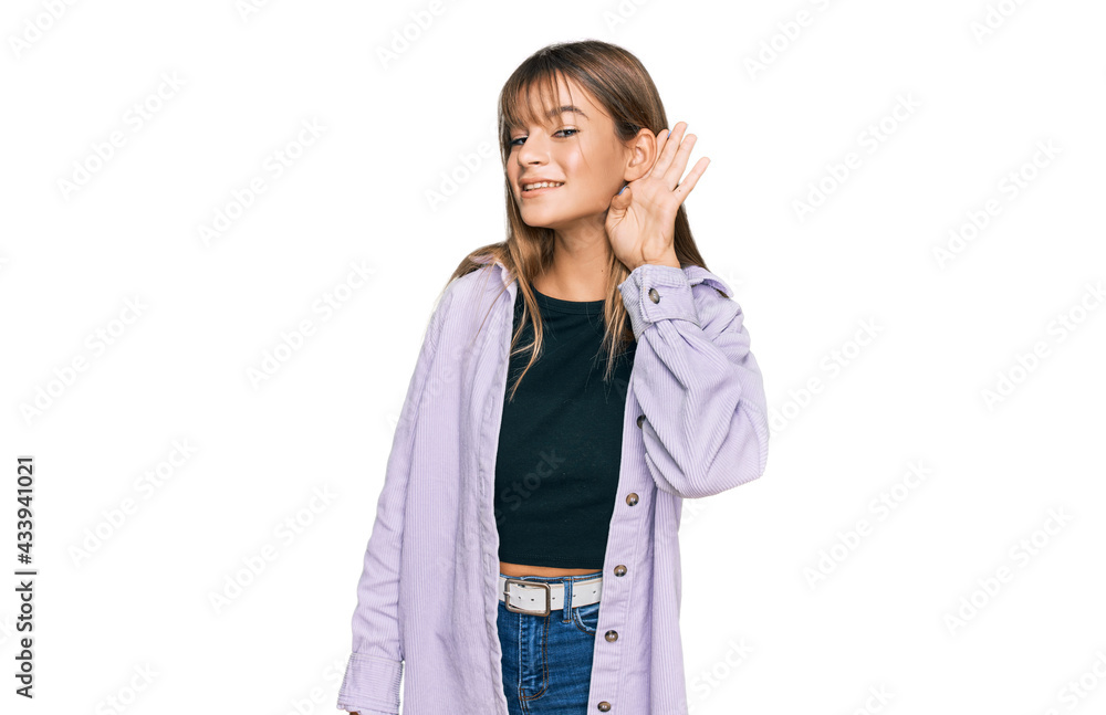 Teenager caucasian girl wearing casual clothes smiling with hand over ear listening an hearing to rumor or gossip. deafness concept. Teenager caucasian girl wearing casual clothes smiling with hand over ear listening an hearing to rumor or gossip. deafness concept.