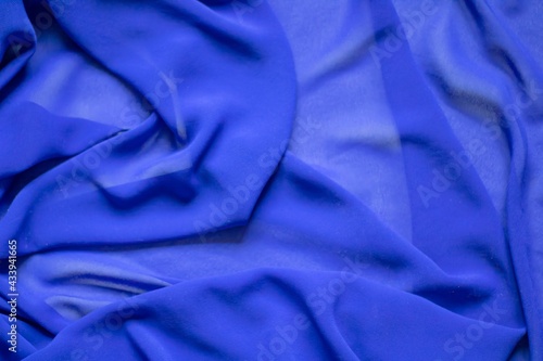 Transparent blue fabric with large folds abstract background. Background of blue fabric, organza