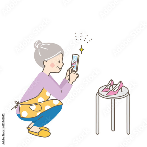 フリマアプリで売る商品をスマホで撮影するシニア女性