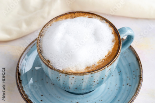 Foam cappuccino on a white wooden background