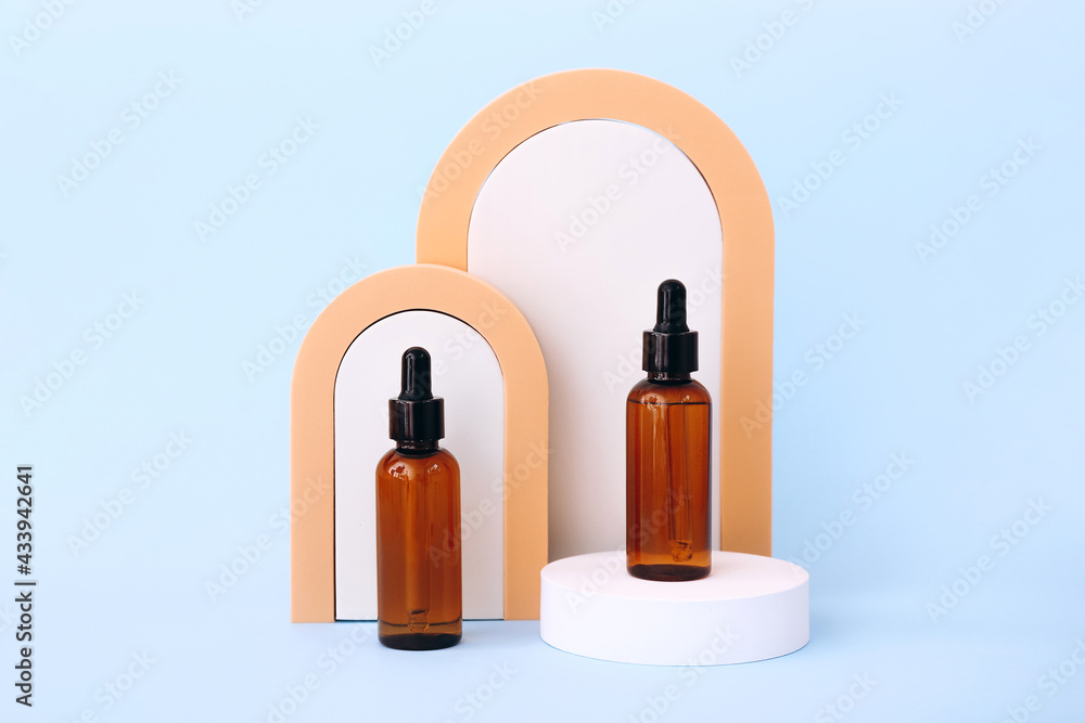 Trendy background with natural cosmetic skincare bottles on blue background. Product presentation. Trendy background with natural cosmetic skincare bottles on blue background. Product presentation.