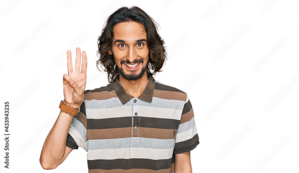 Young hispanic man wearing casual clothes showing and pointing up with fingers number three while smiling confident and happy. Young hispanic man wearing casual clothes showing and pointing up with fingers number three while smiling confident and happy.