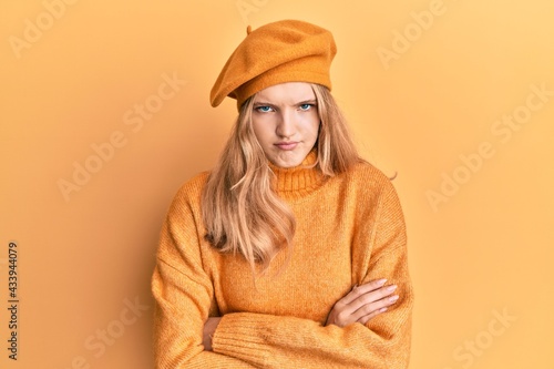 Beautiful young caucasian girl wearing french look with beret skeptic and nervous, disapproving expression on face with crossed arms. negative person.