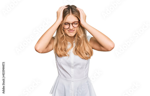 Beautiful young caucasian girl wearing casual clothes and glasses suffering from headache desperate and stressed because pain and migraine. hands on head.