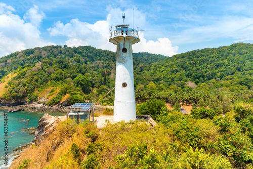 Lighthouse on green coast. Sea lighthouse beacon on rock, Koh Lanta, Thailand