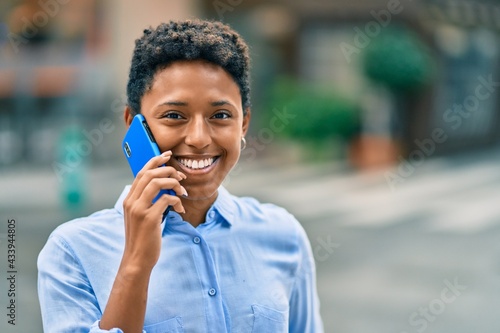 Young african american girl smiling happy talking on the smartphone at the city.