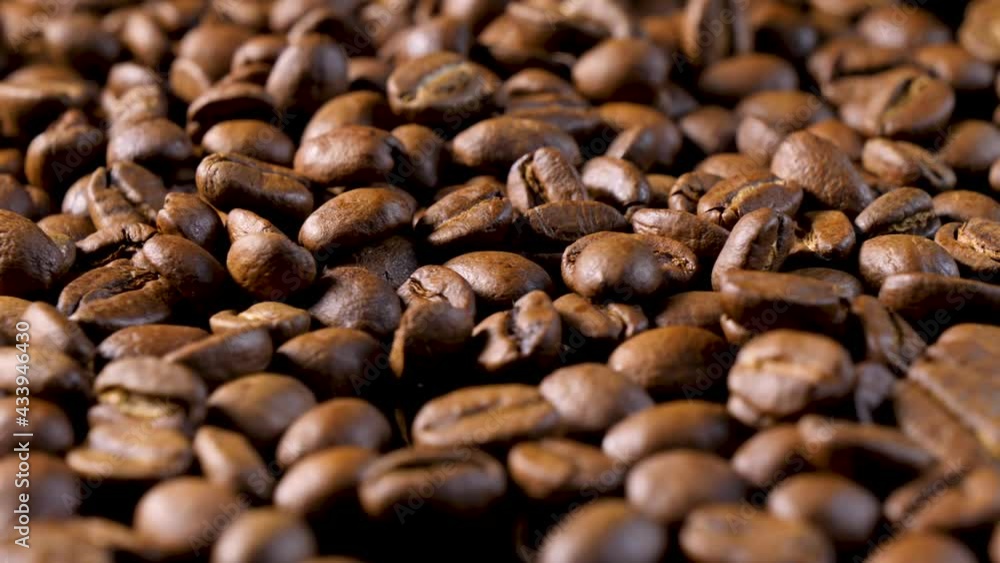 Roasted coffee beans. Smooth motion of arabica coffee seeds. Fragrant coffee beans scrolls slowly around the camera. Slow Motion Close Up of Whole Roasted Robusta Beans Roasted coffee beans. Smooth motion of arabica coffee seeds. Fragrant coffee beans scrolls slowly around the camera. Slow Motion Close Up of Whole Roasted Robusta Beans