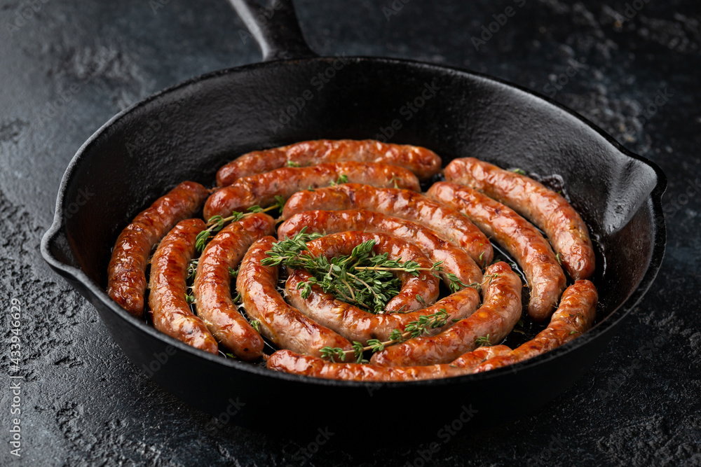 Homemade Pork Sausages in rustic pan with thyme Homemade Pork Sausages in rustic pan with thyme