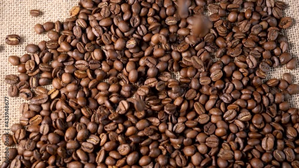 Roasted coffee beans. Smooth motion of arabica coffee seeds. Fragrant coffee beans scrolls slowly around the camera. Slow Motion Close Up of Whole Roasted Robusta Beans Roasted coffee beans. Smooth motion of arabica coffee seeds. Fragrant coffee beans scrolls slowly around the camera. Slow Motion Close Up of Whole Roasted Robusta Beans