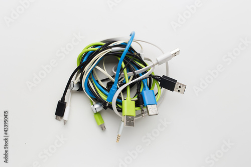 messy wire usb connector and earphone on white background