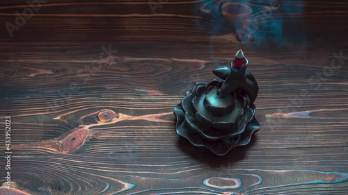 Time lapse of incense cones holder. Ceramic backflow incense burner in the form of lotus flower. Dark mystic concept.