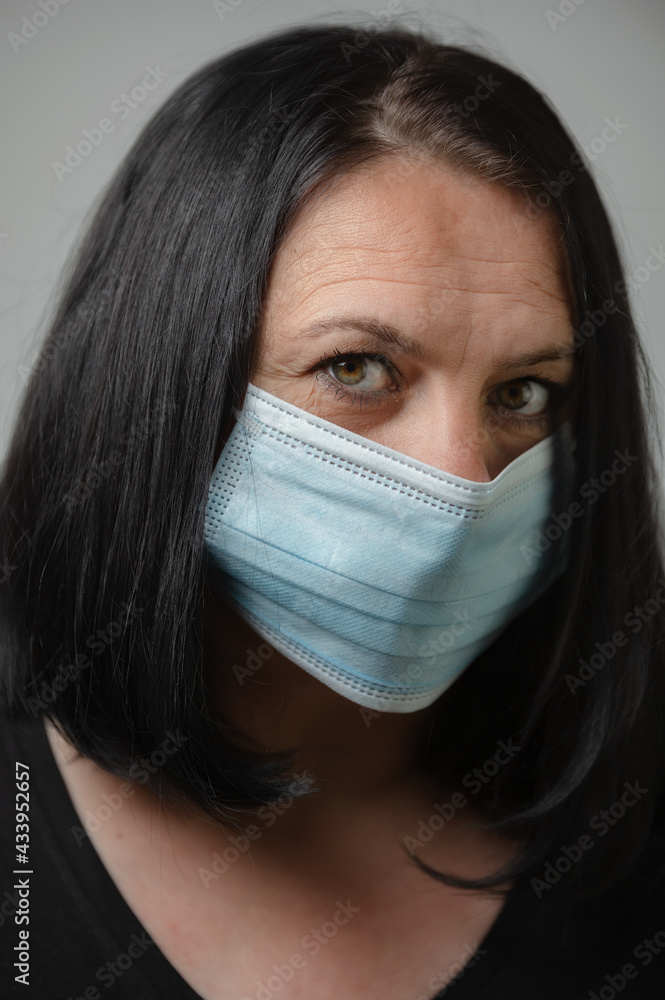 Woman wearing blue medical protective mask to health protection from influenza virus, epidemic and infectious diseases Woman wearing blue medical protective mask to health protection from influenza virus, epidemic and infectious diseases