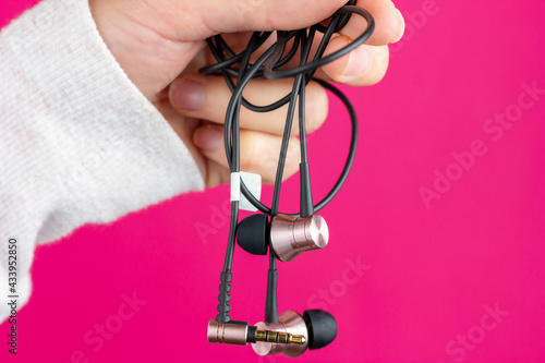 Female hand holds headphones. Audio device for listening to music.