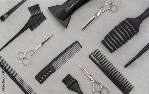 Full frame with hairdressing tools, combs, scissors on a gray background. Hair salon accessories, top view