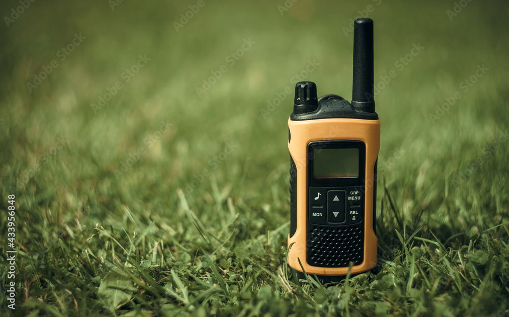 Radio walkie-talkie yellow for transmitting radio waves on green grass.  Search Stock Photo | Adobe Stock