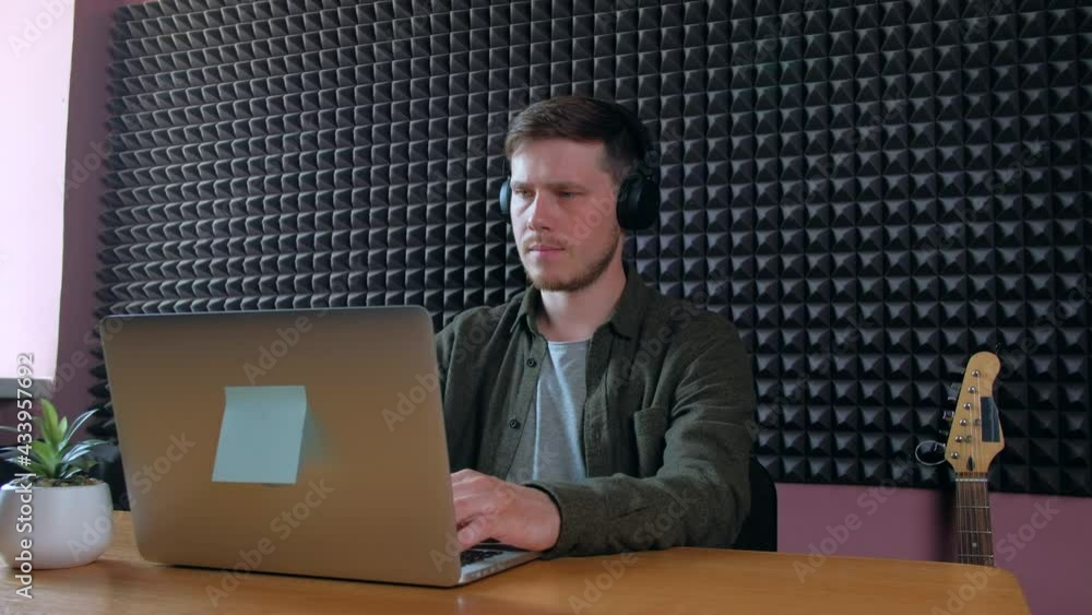Man the musician typing on keyboard laptop. Sound engineer working on notebook in music studio. Man the musician typing on keyboard laptop. Sound engineer working on notebook in music studio.