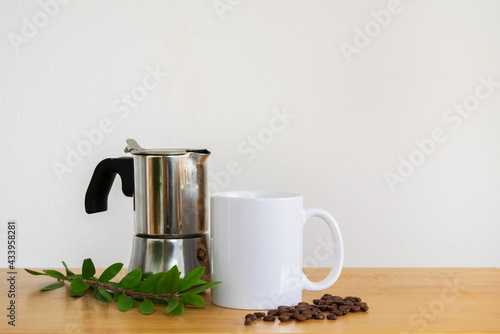 White coffee mug with coffee beans and coffee maker 