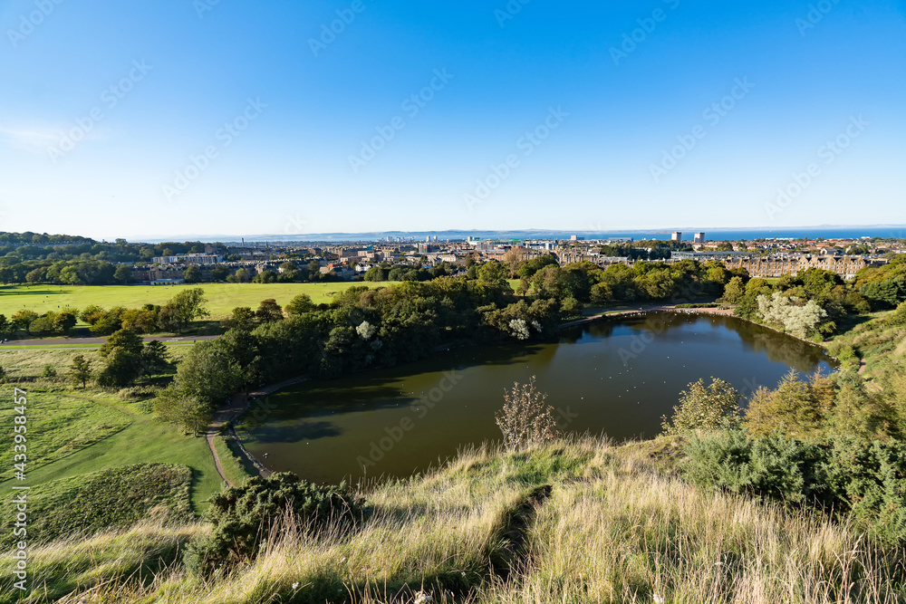 Landscape with St Margaret’s Loch from St Anthony’s Chapel in Edinburgh in Scotland and Meadowbank city in the background.