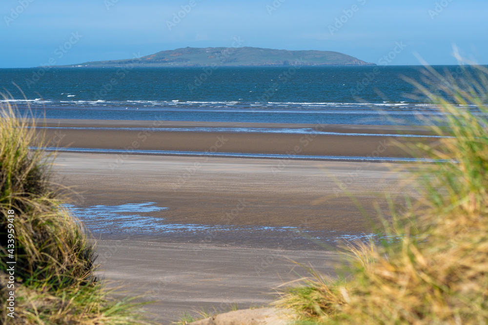 Portmarnock sand beach entrance. Calm morning beach in the spring. sand dunes, lining the city beach. Horizon of the sea