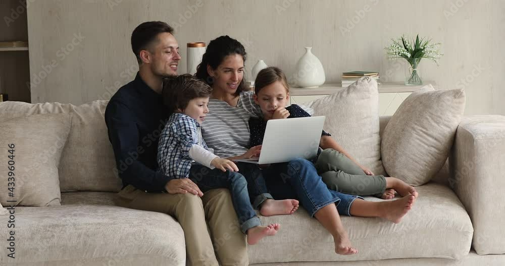 Happy family with kids sit on sofa using laptop making video call, wave hands greeting relatives enjoy remote communication via video conferencing app on device. Comfort modern tech usage, fun concept Happy family with kids sit on sofa using laptop making video call, wave hands greeting relatives enjoy remote communication via video conferencing app on device. Comfort modern tech usage, fun concept