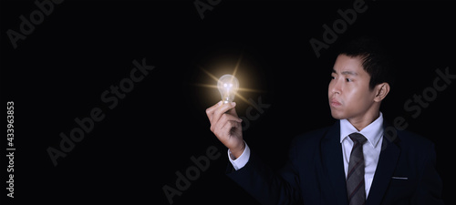 Businessman holding lightbulb.