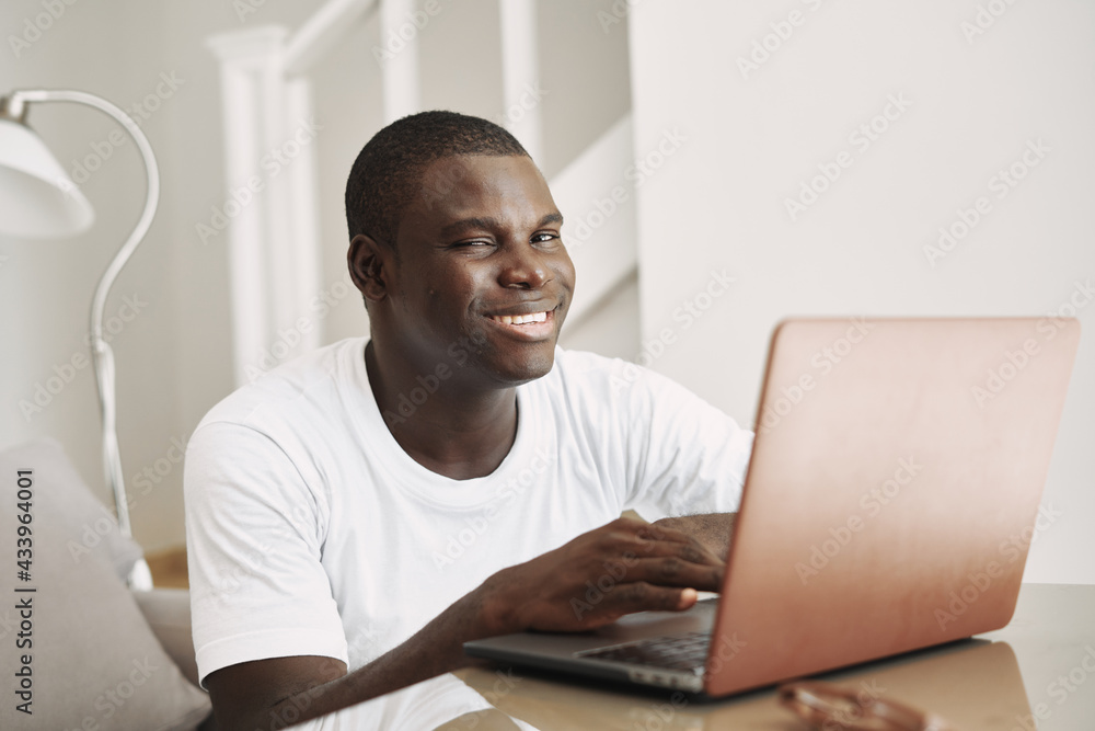 man african appearance at home in front of laptop fun chatting online man african appearance at home in front of laptop fun chatting online