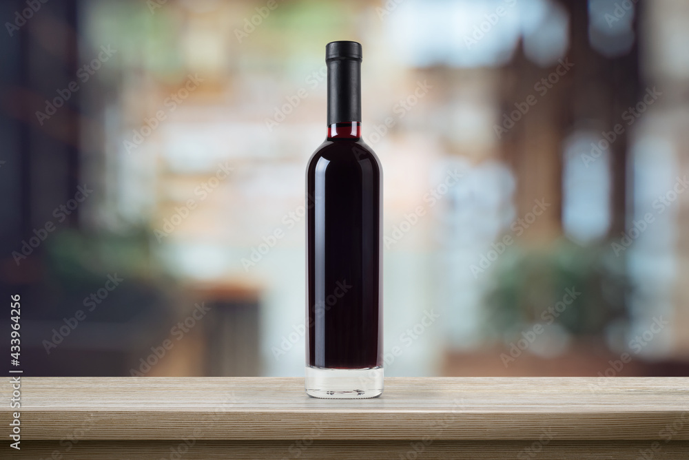 Red wine bottle, on a wooden empty tabletop in front of a blurred background of cafe interior. Wine bottle mockup. 3d illustration.