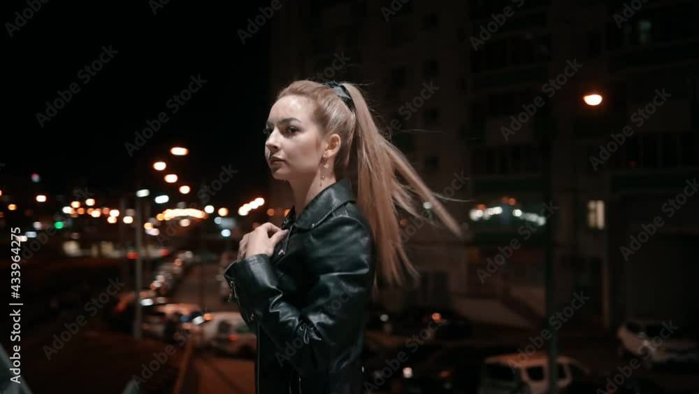 A brutal girl watches the city while walking. Night time. A brutal girl watches the city while walking. Night time.