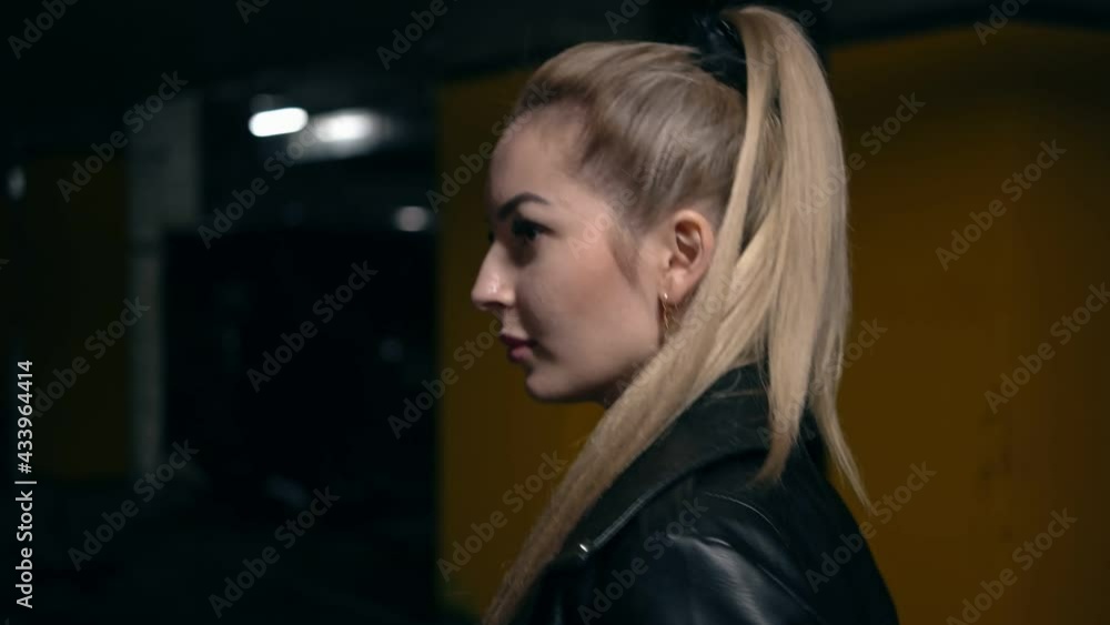 The blonde walks in the night parking lot. Portrait. The blonde walks in the night parking lot. Portrait.