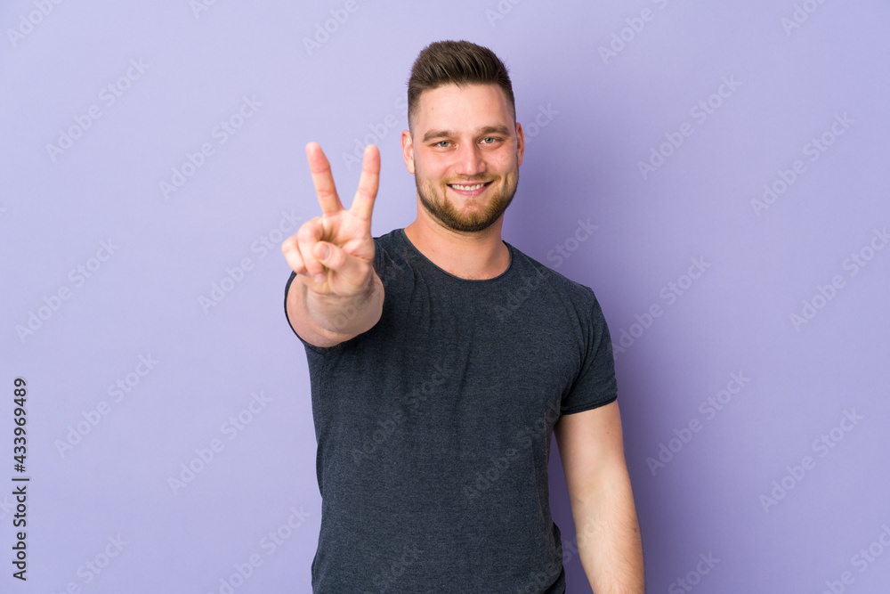 Russian handsome man over isolated background smiling and showing victory sign Russian handsome man over isolated background smiling and showing victory sign