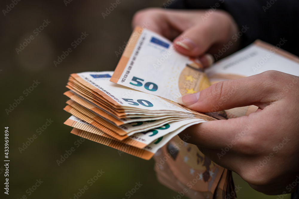 Selective focus shot of a female hand counting euro banknotes - obrazy, fototapety, plakaty 