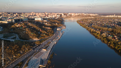 A beautiful river and a city on its banks. Evening park in Ufa. Beautiful sunset light. The clear sky is reflected in the water. Colorful landscape.