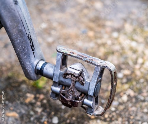 Close and selective focus of a pedal on a road racing bicycle. With selective shallow depth of field and bokeh.