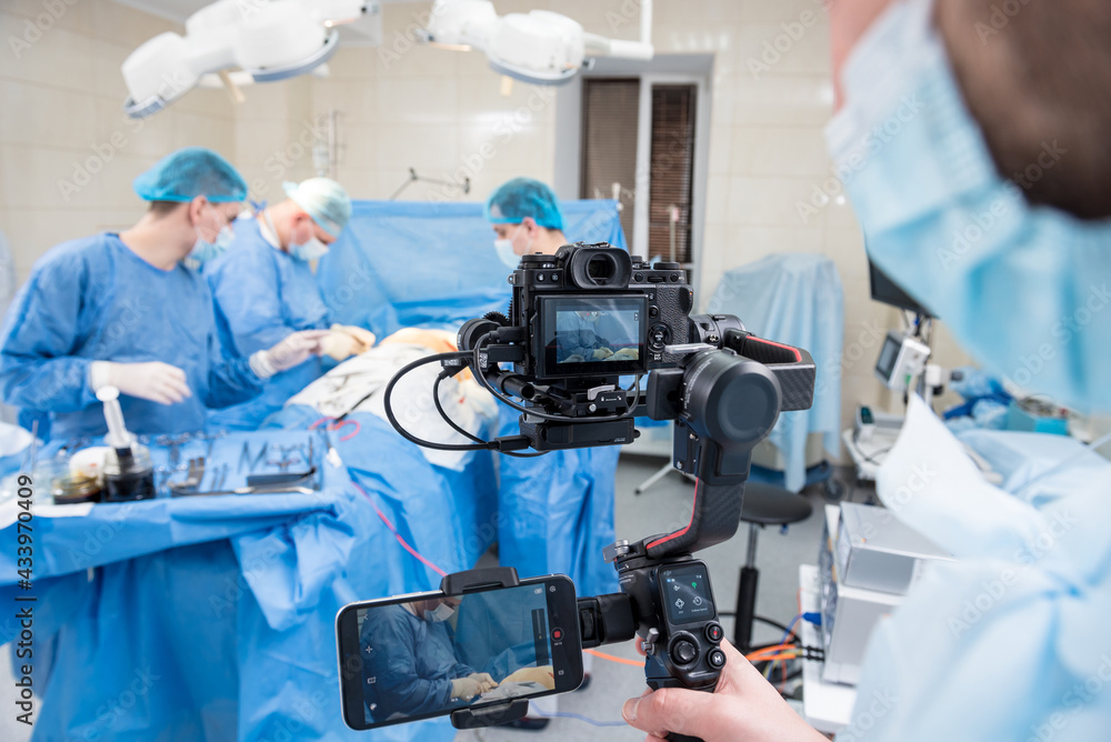 The videographer shoot the surgeon and assistants in the operating room with surgical equipment The videographer shoot the surgeon and assistants in the operating room with surgical equipment