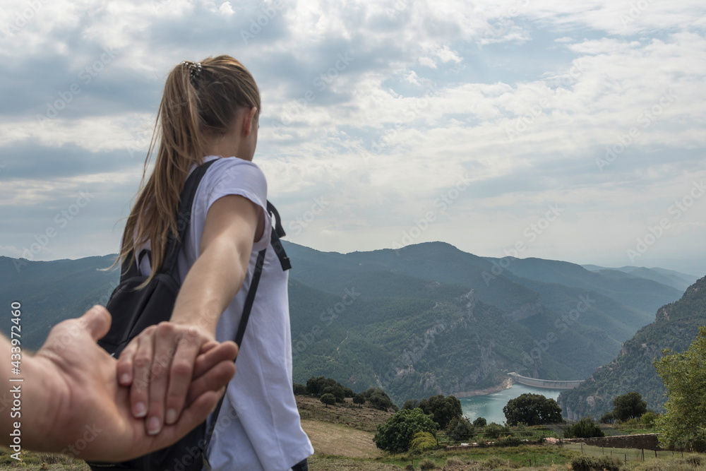 Naklejka premium Young girl shaking hands by the mountain