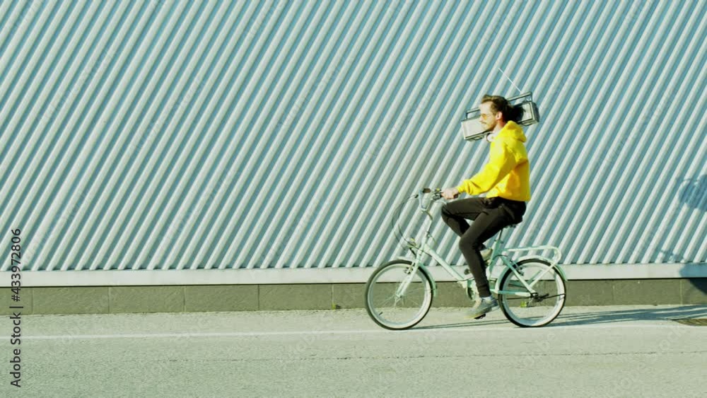 Young man in yellow sweatshirt goes with bicycle and radio. Young man in yellow sweatshirt goes with bicycle and radio.