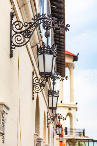 Sochi, Russia, April 12, 2021. Beautiful street lamps at the facade of building of the sea station, one of the tourist symbols of the city, Yachts in the port of Sochi Marina