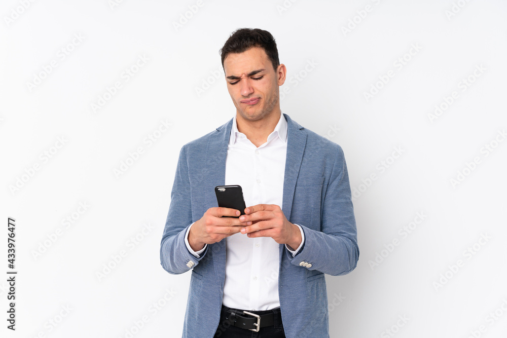 Young handsome businessman on isolated background thinking and sending a message Young handsome businessman on isolated background thinking and sending a message