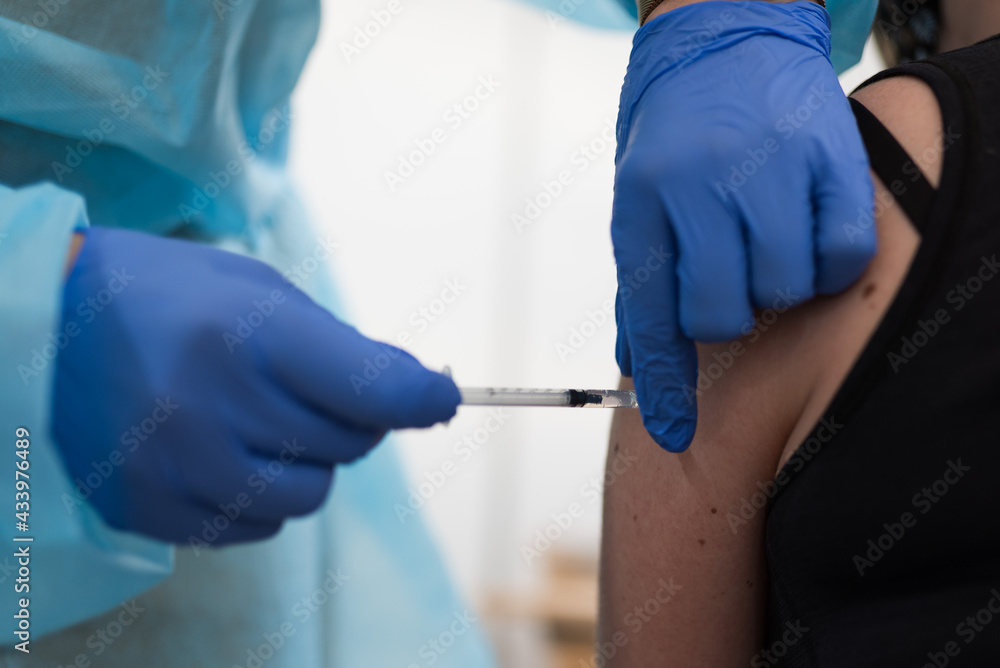 Hands of a doctor vaccinates against Covid-19 a man in the arm. Hands of a doctor vaccinates against Covid-19 a man in the arm.