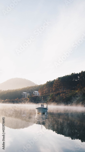 A small boat on a foggy lake in Dalat, Vietnam